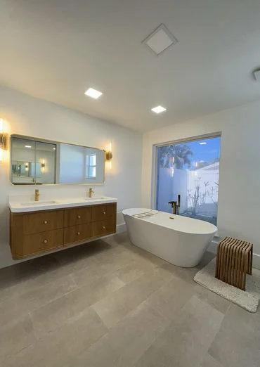 Modern bathroom with freestanding tub, vanity and bright finishes