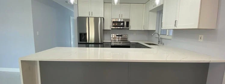 Kitchen after renovation, with a brighter island, updated cabinets and modern finishes