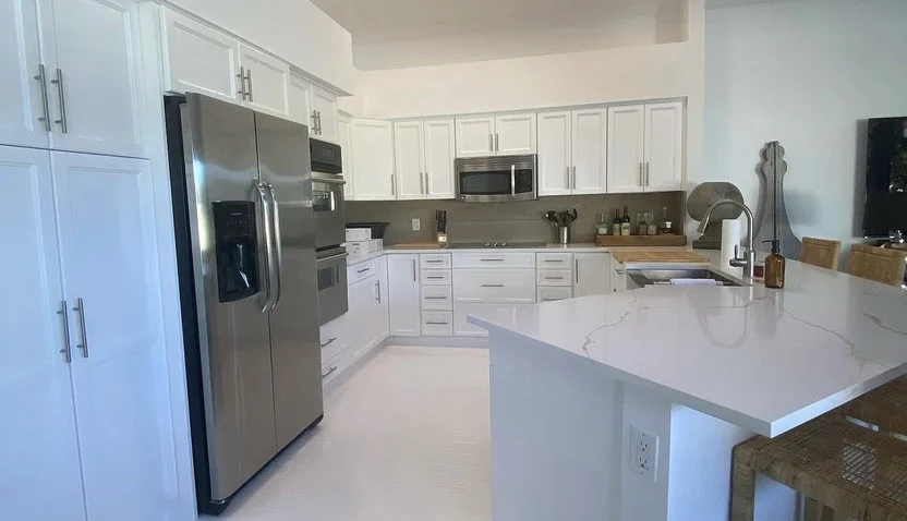 Kitchen after refresh, with repainted cabinets, brighter surfaces and updated finishes