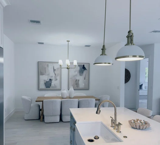 Bright interior dining and kitchen area with pendant fixtures
